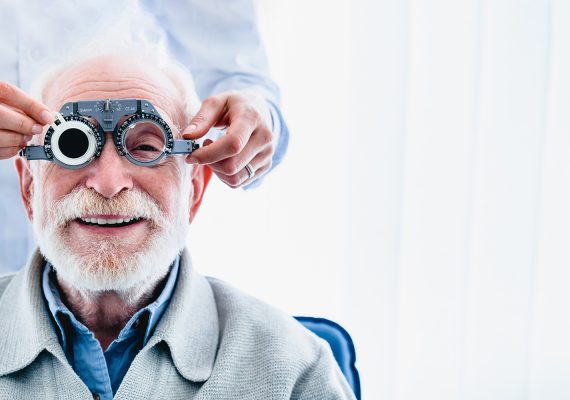 Portrait,Of,A,Happy,Mature,Male,Patient,Undergoing,Vision,Check Portrait of a happy mature male patient undergoing vision check with special ophthalmic glasses